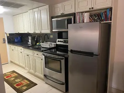 a kitchen with a stainless steel refrigerator and white cabinets at All you need around you in Sunny Isles Beach