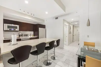 a kitchen with a counter with black chairs in it at Exclusive Doral Villa with Luxury Amenities in Miami