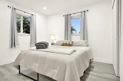 a white bedroom with a large bed and two windows at Koze 2 Bedroom Duplex Home with King & Queen Beds, Near Everything Trendy in Miami