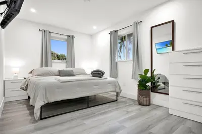 a white bedroom with a bed and a mirror at Koze 2 Bedroom Duplex Home with King & Queen Beds, Near Everything Trendy in Miami