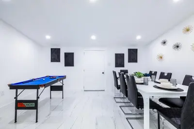 a dining room with a ping pong table and chairs at The Glow House w Cinema, Disco, Pool, BBQ, 9 beds in Ives Estates