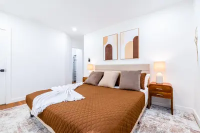 a bedroom with a large bed and two lamps at The Glow House w Cinema, Disco, Pool, BBQ, 9 beds in Ives Estates