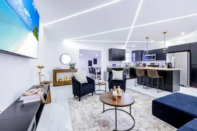 an open living room and kitchen in a apartment at The Glow House w Cinema, Disco, Pool, BBQ, 9 beds in Ives Estates