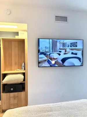 a flat screen tv on the wall of a bedroom at 2 bedroom Stylish Condo Downtown Pool Gym spa in Miami