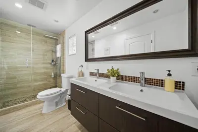 a bathroom with a sink and a toilet and a mirror at Miami Oasis- Pool & Game Fun in Miami