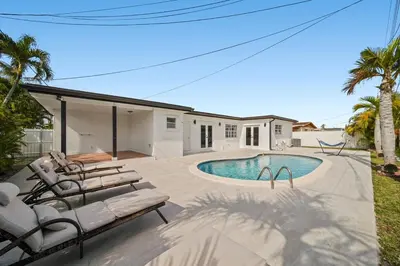 a swimming pool with lounge chairs and a house at Miami Oasis- Pool & Game Fun in Miami