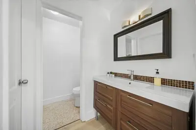 a bathroom with a sink and a mirror and a toilet at Miami Oasis- Pool & Game Fun in Miami