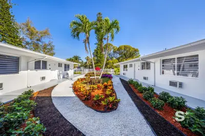 a building with a courtyard with plants and palm trees at Stylish 1-BD Apt in Miami Gym, BBQ, Free Parking in Miami