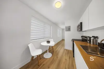 a kitchen with a sink and a table in a room at Stylish 1-BD Apt in Miami Gym, BBQ, Free Parking in Miami