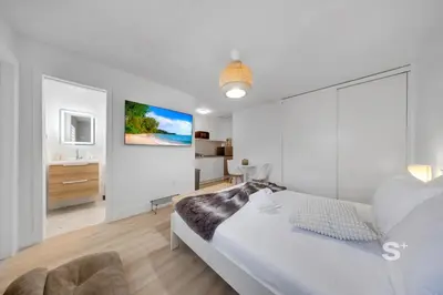 a white bedroom with a bed and a bathroom at Modern Studio in Miami Gym, BBQ, Free Parking in Miami