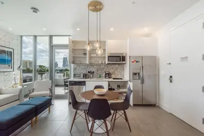 a kitchen and living room with a table and chairs at Apto 2Q Estiloso a 5min da Praia de South Beach in Miami Beach