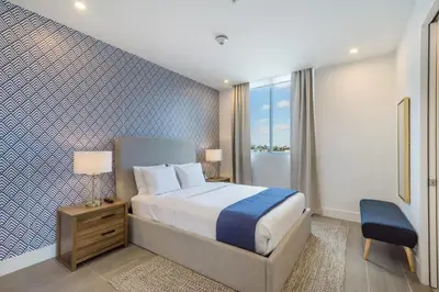 a bedroom with a bed and a blue and white wall at Apto 2 Quartos a 5min da Praia de South Beach in Miami Beach