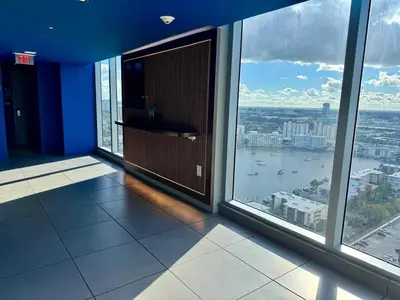an empty room with large windows in a building at 1BR on Miami Beach with Beach Service & Near Mall in Hallandale Beach