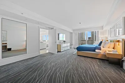 a large bedroom with a blue bed and a kitchen at Ritz-Carlton Luxury Oceanview 3-Bedroom Residence in Fort Lauderdale