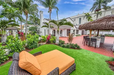 an outdoor patio with a table and chairs at Grand historic Residence Walk to beach Heated Pool Outdoor kitchen Hibiscus Key Residences in Fort Lauderdale