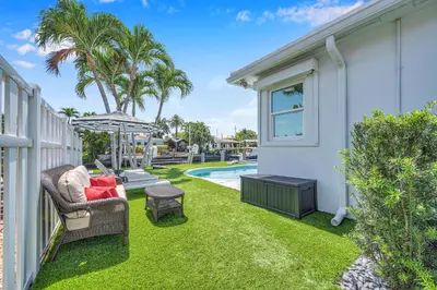 a yard with a chair and an umbrella next to a house at Waterfront Bungalow Heated Pool Pineapple Key in Fort Lauderdale