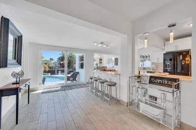 a kitchen with a table and stools in it at Waterfront Bungalow Heated Pool Pineapple Key in Fort Lauderdale