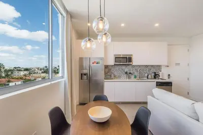 a kitchen and living room with a table and a couch at Apto Moderno a 5min da Praia em South Beach in Miami Beach