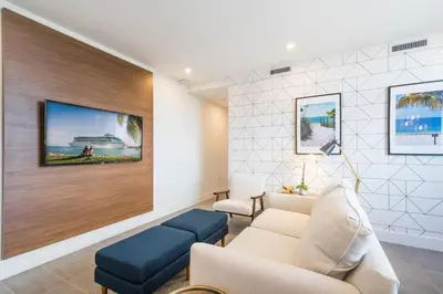 a living room with a couch and a tv on a wall at Apto Moderno a 5min da Praia em South Beach in Miami Beach