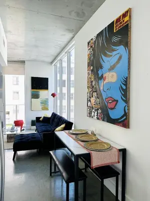 a living room with a table and a painting on the wall at Pop Art Sunlit Apartment Prime Miami Pool Free Parking in Miami