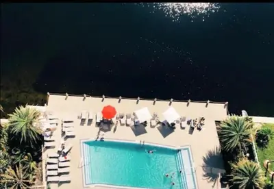 an overhead view of a pool with chairs and a red umbrella at Studio Beach Apmt 2 Full Q Beds, Amazing View in Hallandale Beach
