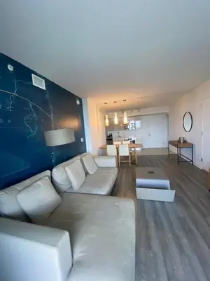 a living room with a white couch and a table at Beach, pool, and Gym 2B 2B Near Gulfstream & Mall in Hallandale Beach