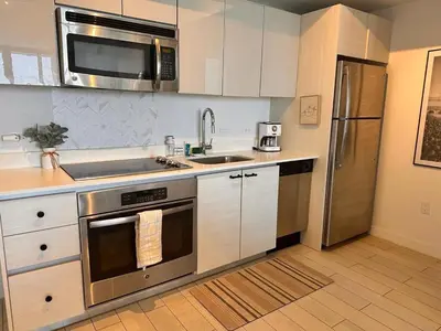 a kitchen with a stainless steel stove and refrigerator at 1BR 1BA with Pool & Sun in Miami Beach in Hallandale Beach