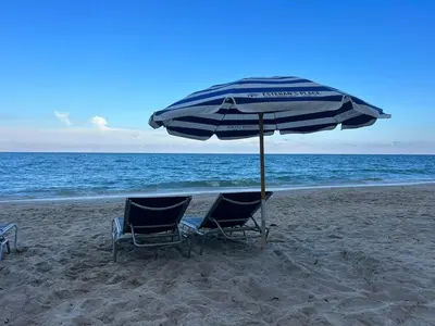 two chairs and an umbrella on the beach at Beautiful Studio in Hallandale with Beach & Pool in Hallandale Beach