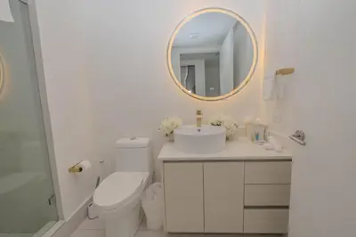 a bathroom with a toilet and a sink and a mirror at Amazing 2B 2B Luxury Beach Apmt in Hallandale Beach