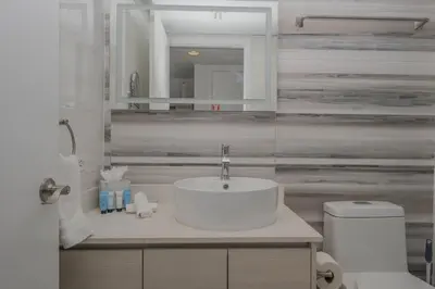 a white bathroom with a sink and a toilet at Amazing 2B 2B Luxury Beach Apmt in Hallandale Beach