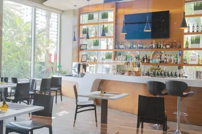 a restaurant with tables and chairs and a bar at Amazing 2B 2B Luxury Beach Apmt in Hallandale Beach