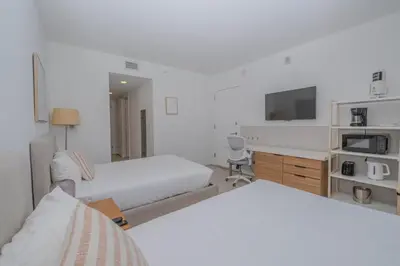 a hotel room with two beds and a tv at Ocean views pool gym and more in Hallandale Beach