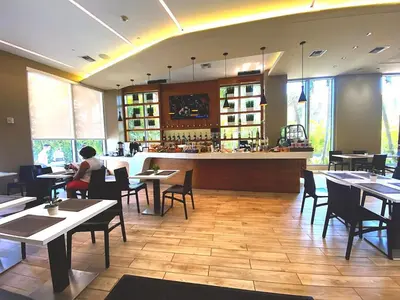 a restaurant with tables and chairs and a bar at Ocean views pool gym and more in Hallandale Beach