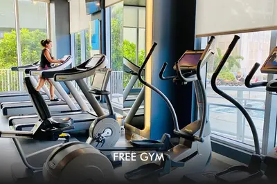 a woman on a treadmill in a gym at Dream Beach Apt 1BR, Kitchen & Pool Access in Hallandale Beach