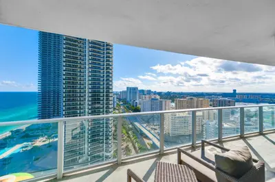a balcony with a view of the ocean and buildings at Stylish Condo Steps From the Beach! in Hollywood
