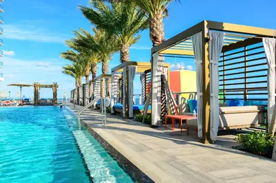 a resort with a pool and palm trees at Stylish Condo Steps From the Beach! in Hollywood