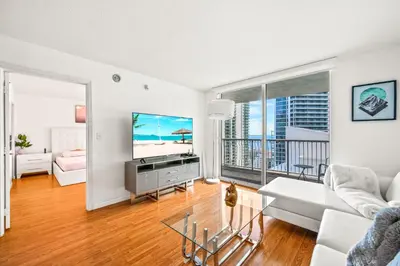a living room with a couch and a tv at Sky High Living with Incredible Views in Miami