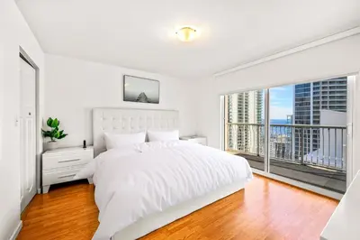 a bedroom with a white bed and a large window at Sky High Living with Incredible Views in Miami