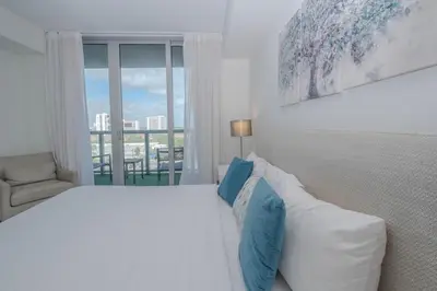 a white bedroom with a bed and a window at 2B 2B Relax in Miami Beach and Luxury services in Hallandale Beach