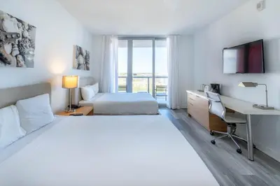 a hotel room with two beds and a desk and a computer at 2B 2B Beachfront Pool Gym and Restaurant 2004 in Hallandale Beach