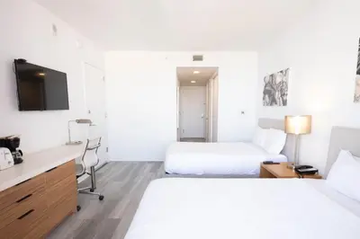 a hotel room with two beds and a desk at 2B 2B Beachfront Pool Gym and Restaurant 2004 in Hallandale Beach