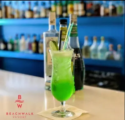 a green drink in a glass sitting on a table at Your Miami retreat beach pool and Aventura Mall in Hallandale Beach