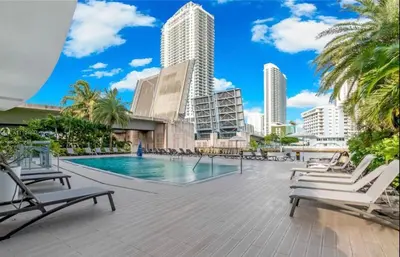 a swimming pool with chaise lounge chairs and buildings at Perfect getaway beach pool and Aventura Mall 2209 in Hallandale Beach