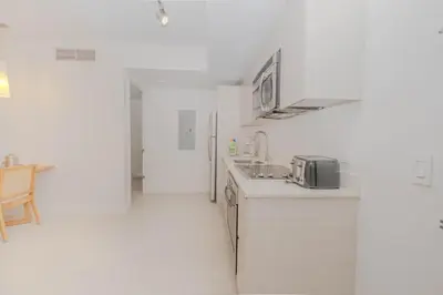 a white kitchen with a sink and a refrigerator at Enjoy Miami 2B 2B pool beach and Aventura Mall in Hallandale Beach