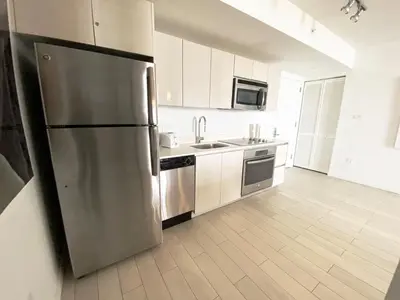 a large kitchen with a stainless steel refrigerator at Beach, pool, and Gym 2B 2B Near Gulfstream & Mall in Hallandale Beach