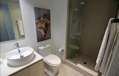 a bathroom with a toilet and a sink and a shower at Beach, pool, and Gym 2B 2B Near Gulfstream & Mall in Hallandale Beach