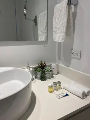 a white bathroom with a sink and a mirror at Beach, pool, and Gym 2B 2B Near Gulfstream & Mall in Hallandale Beach