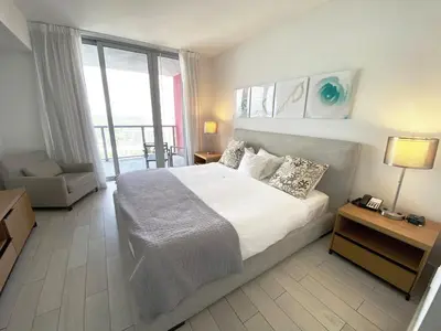 a bedroom with a large bed and a large window at Beach, pool, and Gym 2B 2B Near Gulfstream & Mall in Hallandale Beach