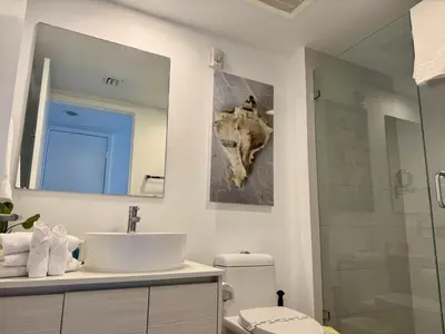 a bathroom with a sink and a mirror and a toilet at Getaway in Miami 2B 2B beachfront near Aventura 3003 in Hallandale Beach