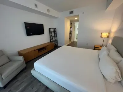 a bedroom with a large white bed and a couch at Miami Beach Cozy 1B withe Pool and Beach Service1507 in Hallandale Beach